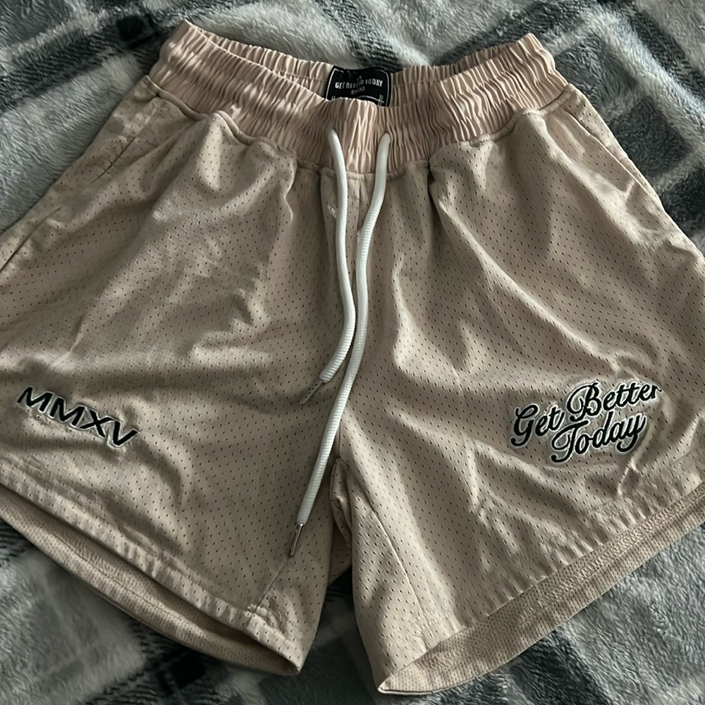 Women GBT Beige basket ball shorts with green embroidered lettering.